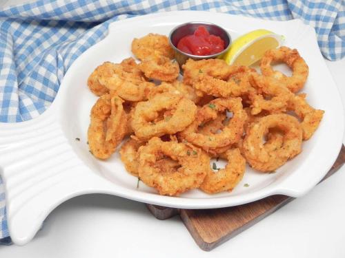 a plate of shrimp on a plate with a sauce at Vinary Hotel Sukhumvit in Bangkok