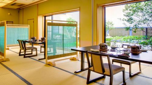 a room with tables and chairs and a large window at Kagiya in Minamiizu