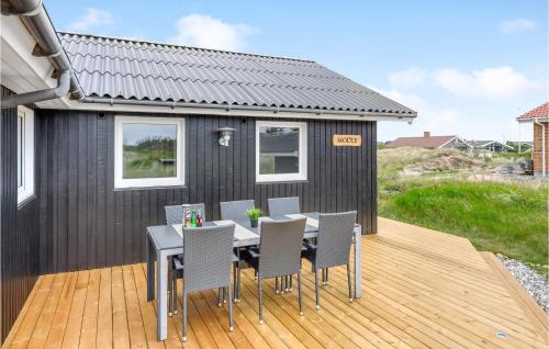 a black tiny house with a table and chairs on a deck at Holiday Home Molsvej Ringkøbing Vi in Søndervig