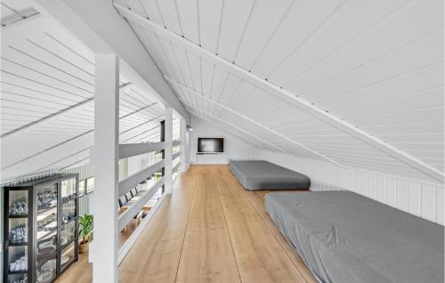 a attic bedroom with a bed and a tv at Holiday Home Molsvej Ringkøbing Vi in Søndervig