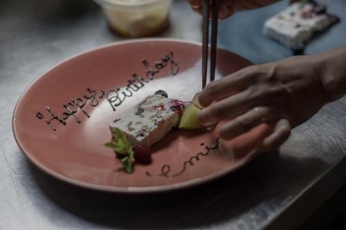 a person eating a piece of cake on a pink plate at ruisseau in Ogawa
