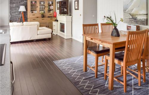 a kitchen and living room with a wooden table and chairs at 3 Bedroom Awesome Apartment In Skjeberg in Skjeberg