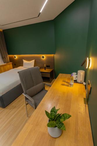 a room with a bed and a table with a chair at Sansar Hotel in Erdenet