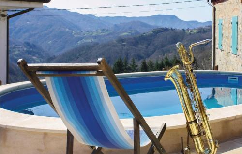 a chair with a saxophone next to a swimming pool at Gorgeous Home In Bagni Di Lucca Lu in Bagni di Lucca