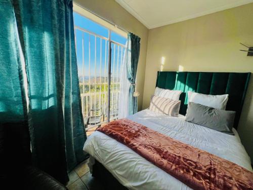 ロードポートにあるHoneyhills Excellence Resorts Aのベッドと大きな窓のある寝室