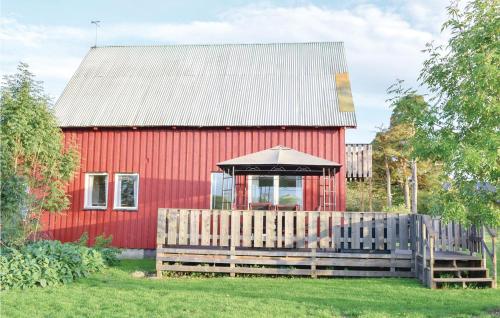 a red barn with an umbrella over a wooden fence at Nice Home In Romakloster With Wifi in Romakloster