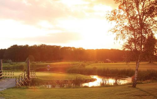 a golf course with a pond and a rainbow at Fewo Schloss Bothmer in Kaschow