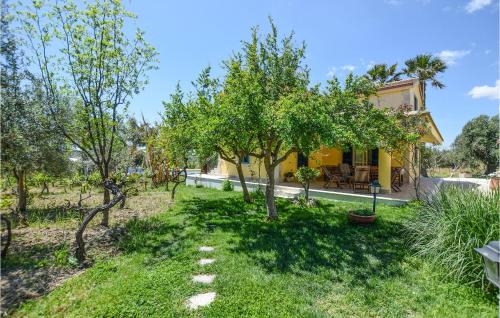 a garden with trees and a yellow house at 5 Bedroom Awesome Home In Noto in Noto