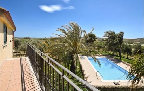 a balcony with a swimming pool and palm trees at 5 Bedroom Awesome Home In Noto in Noto