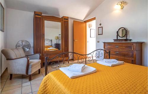 a bedroom with a bed and a chair and a mirror at 5 Bedroom Awesome Home In Noto in Noto