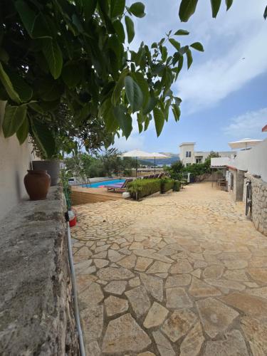 a stone walkway leading to a swimming pool at Villa Papa in Ksamil