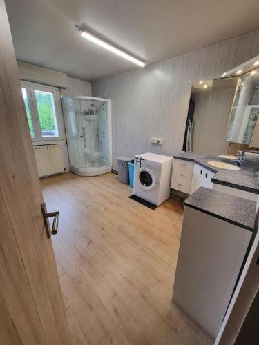 une grande pièce avec une machine à laver et une cuisine dans l'établissement Au ptit bonheur comtois, à Rosières-sur-Barbèche