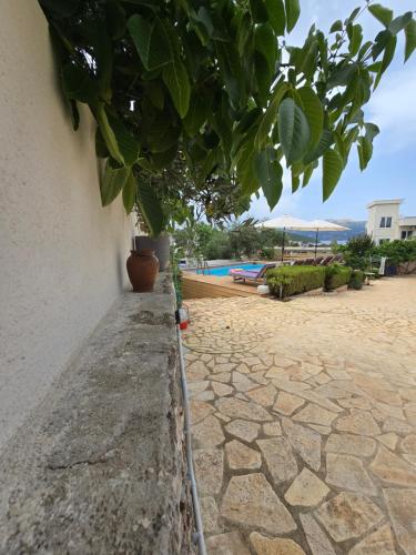 a plant on the side of a building with a water hose at Villa Papa in Ksamil