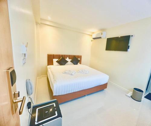 a bedroom with a bed with a television and a tv at ABC HA Hotel Bangkok in Bangkok