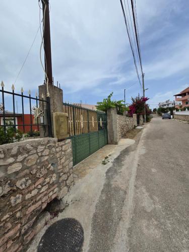a street with a stone wall and a fence at Villa Papa in Ksamil