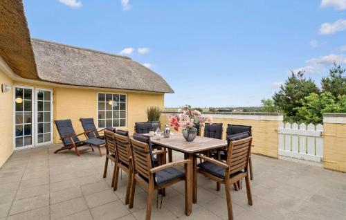 a patio with a wooden table and chairs at Lovely Home In Ringkøbing With Wifi in Søndervig