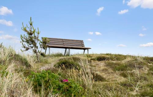 a park bench sitting on top of a hill at Lovely Home In Ringkøbing With Wifi in Søndervig