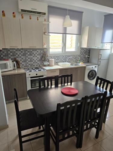 a kitchen with a black table and chairs and a stove at Villa Papa in Ksamil