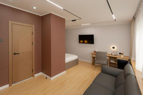 a living room with a couch and a bedroom at Sansar Hotel in Erdenet