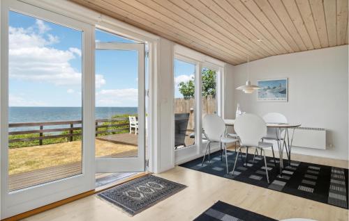 a dining room with a table and views of the ocean at Holiday Home Nebbe Oddevej in Rønne