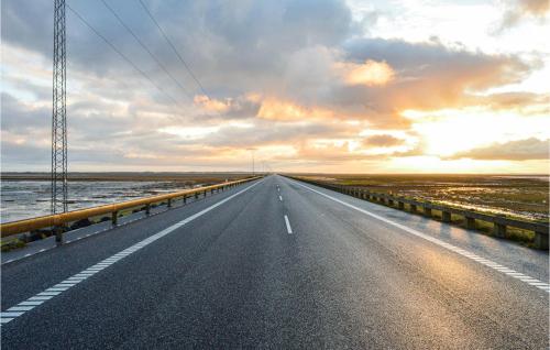 an empty road with the sunset in the background at Holiday Home Kærhøgen Rømø Denm in Rømø Kirkeby