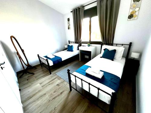 two beds in a room with blue and white at Queens Gardens Bliss in Paphos City