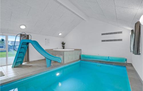 a swimming pool with a blue slide in a room at Nice Home In Sydals With Sauna in Høruphav