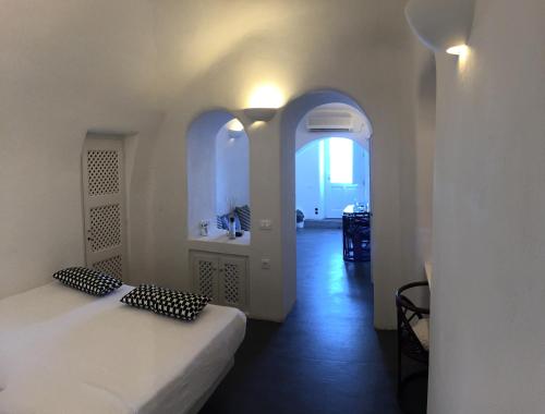 a room with a bed and a bathroom with a sink at Altana Cliffside Villas in Imerovigli