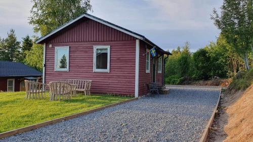 a red house with a table and chairs in front of it at Fully renovated cottage with great hilltop views in Undenäs