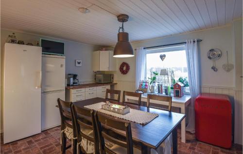 a kitchen with a dining table and a refrigerator at Nice Home In Strömstad With Wifi in Strömstad