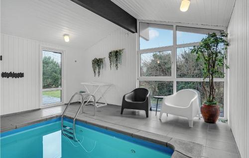 a living room with a pool and a table and chairs at Nice Home In Glesborg With Kitchen in Bønnerup Strand