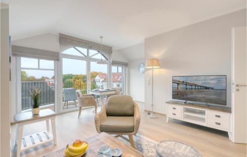 a living room with a flat screen tv and a table at Baltischer Hof Apartment 67 in Boltenhagen