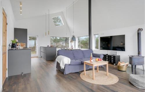 a living room with a blue couch and a table at Three-Bedroom Holiday Home In Hundested in Hundested