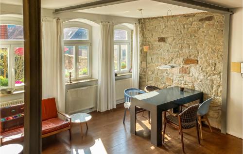 a dining room with a table and chairs and a stone wall at 3 Bedroom Nice Home In Zeil Am Main in Zeil