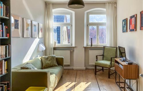 a living room with a couch and a chair and windows at 3 Bedroom Nice Home In Zeil Am Main in Zeil