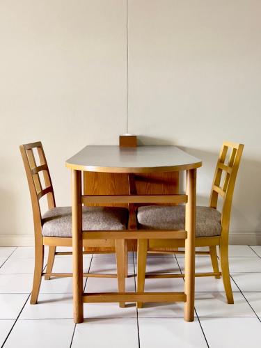 a wooden table with two chairs and a table and a table and chairsuggest at BU Place Hotel in Bangkok