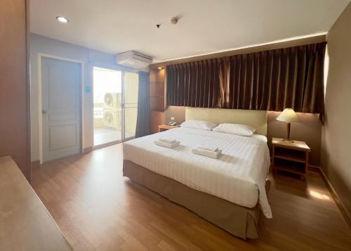 a bedroom with a large bed and a large window at BU Place Hotel in Bangkok