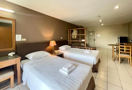 a hotel room with two beds and a table at BU Place Hotel in Bangkok
