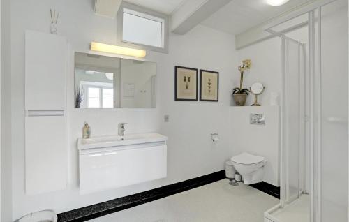 a white bathroom with a sink and a toilet at Holiday Home Højslev 40 in Bøstrup