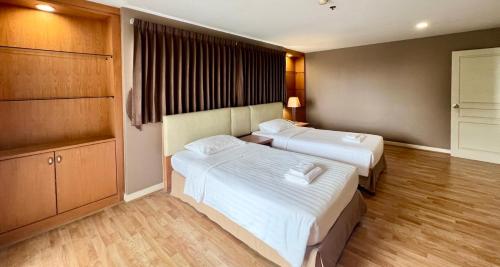 a hotel room with two beds and a kitchen at BU Place Hotel in Bangkok