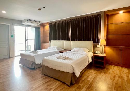 a hotel room with two beds and a window at BU Place Hotel in Bangkok