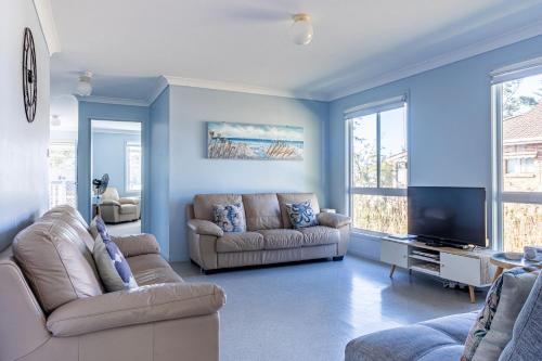 a living room with two couches and a flat screen tv at Perfect for Two Families in Sussex inlet