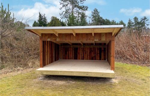 a wooden out house with a roof on the grass at Holiday Home Kap Farvel Rømø Ii in Bolilmark