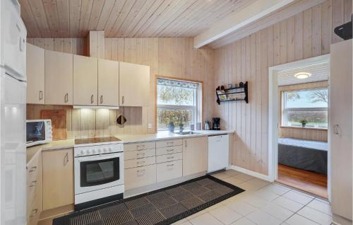 a kitchen with white cabinets and a sink and a window at Holiday Home Egernsund With Patio 319 in Egernsund