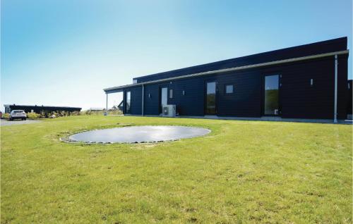 a building with a pond in the middle of a yard at Three-Bedroom Holiday Home In Haderslev in Haderslev