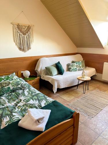 a bedroom with two beds and a couch at Kokosek Pokoje Gościnne in Mielno