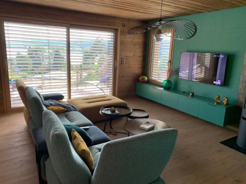 un salon avec un canapé et une télévision dans l'établissement Vue lac, à Montperreux
