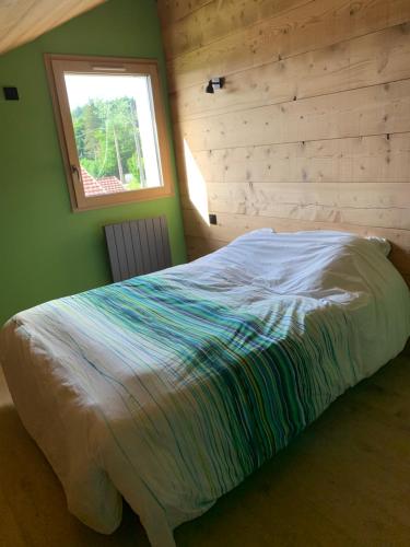 Ce lit se trouve dans une chambre dotée d'une fenêtre. dans l'établissement Vue lac, à Montperreux