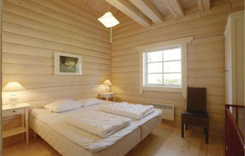 a bedroom with a bed in a room with wooden walls at Holiday Home Frederiksvej Nexø Denm in Balke