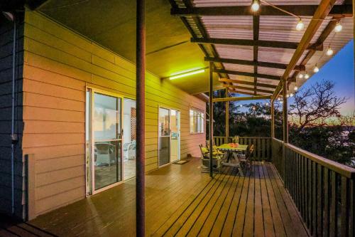 a porch of a house with a table on it at Seaview - Charming Two-Bedroom Home with Stunning Views of the Historic Bay of 1770 in Seventeen Seventy